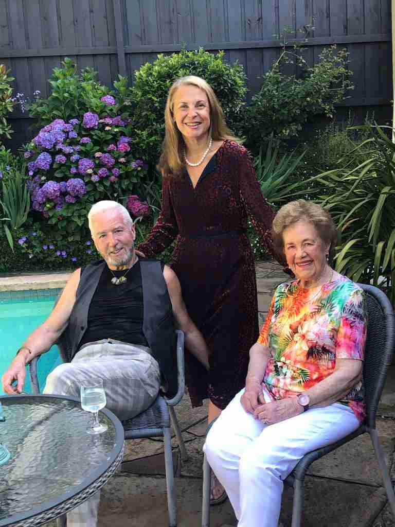 3 people sitting beside a pool